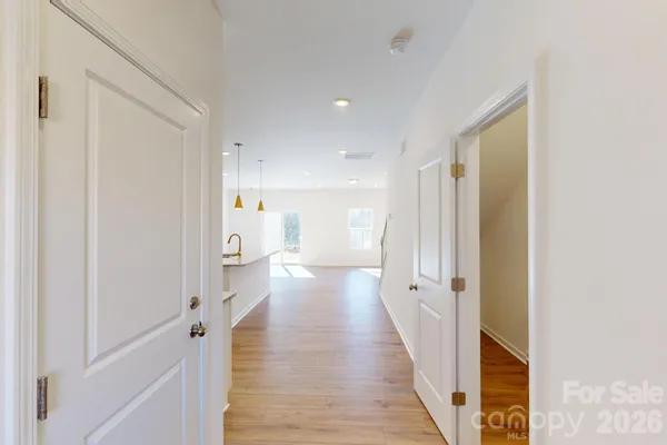 a view of a hallway with wooden floor and staircase