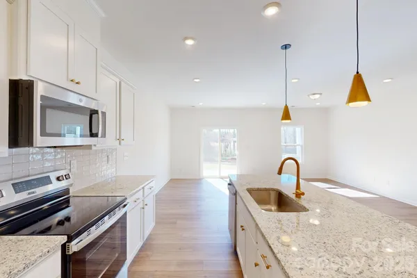 a kitchen with sink a stove and cabinets