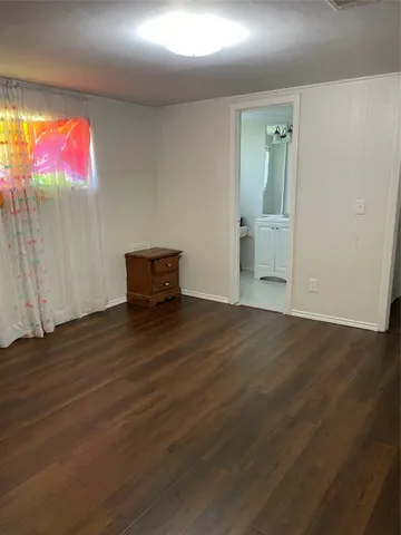 an empty room with wooden floor and bench