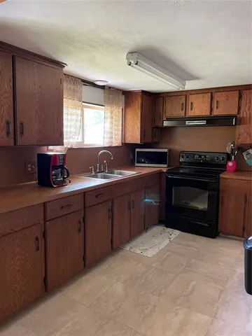 a kitchen with stainless steel appliances granite countertop a stove sink and cabinets