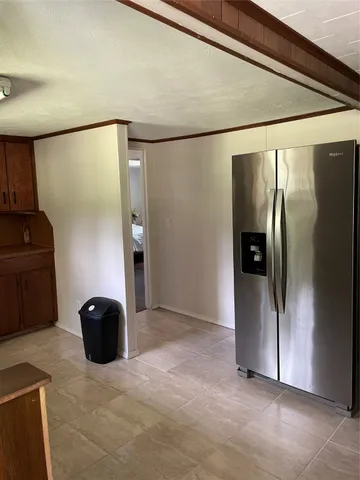 a view of a refrigerator in kitchen and a glass window