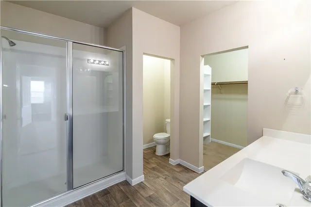 a bathroom with a granite countertop sink a toilet and shower