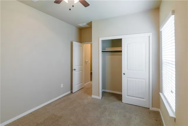 an empty room with closet and windows