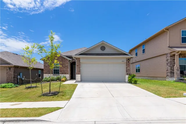 a front view of a house with a yard and garage