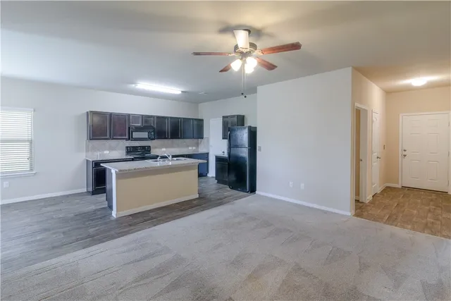 a view of kitchen with refrigerator and microwave
