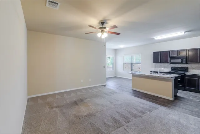 a view of kitchen with refrigerator stove microwave and cabinets