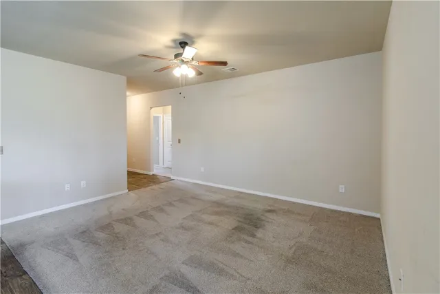 an empty room with a chandelier fan