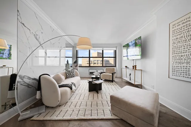 a living room with furniture fireplace and a large window