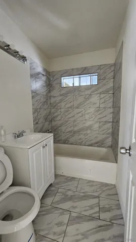 a bathroom with a toilet a sink and bathtub