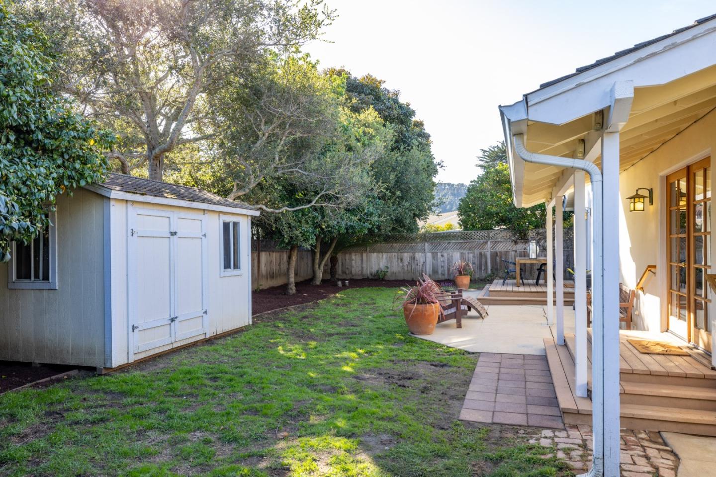 26571 Aspen Place Carmel, CA 93923 - Photo 34 of 46 a view of a backyard with table and chairs potted plants and a large tree