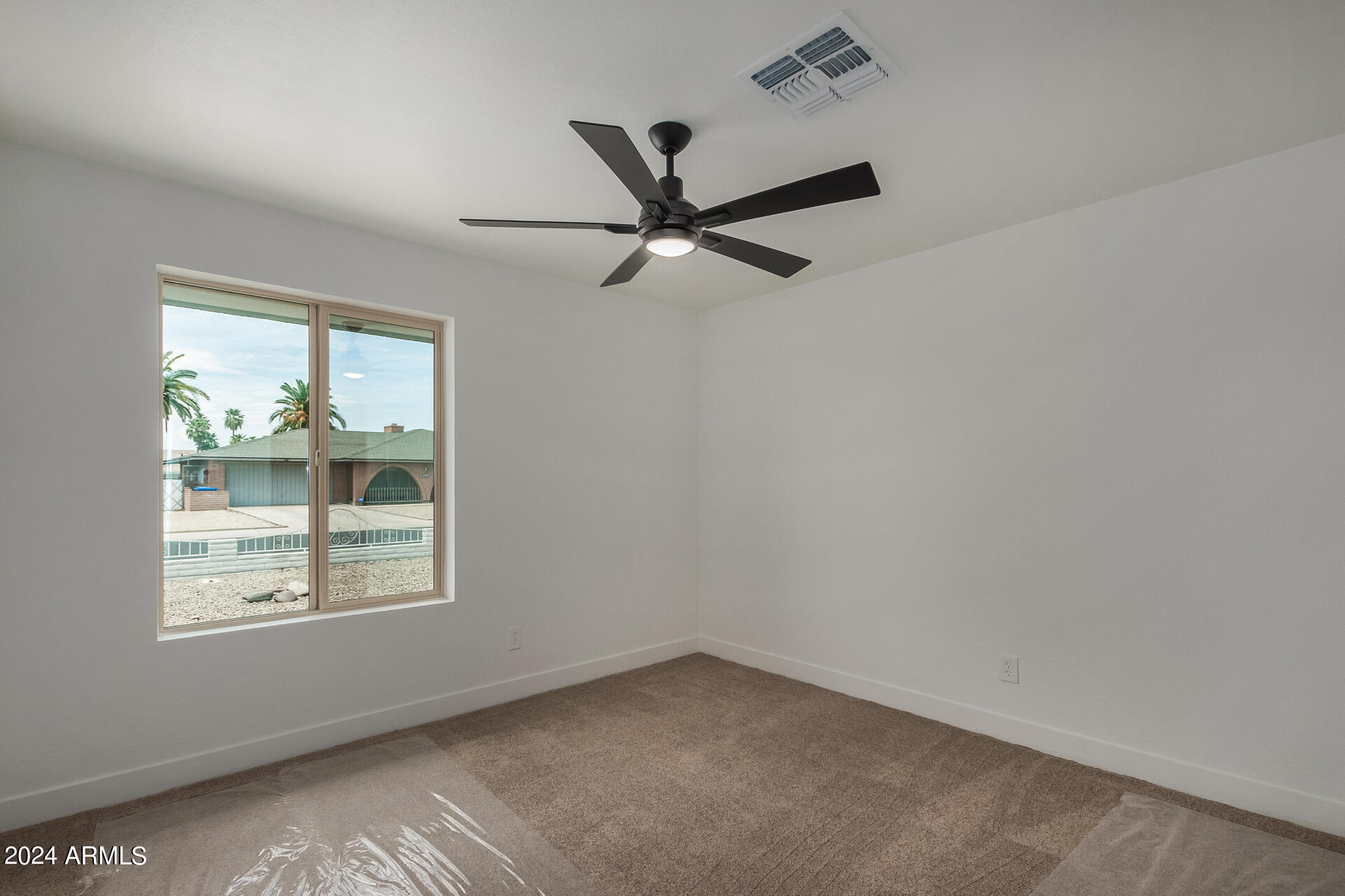 4109 West Hatcher Road Phoenix, AZ 85051 - Photo 23 of 33 an empty room with a window and a fan