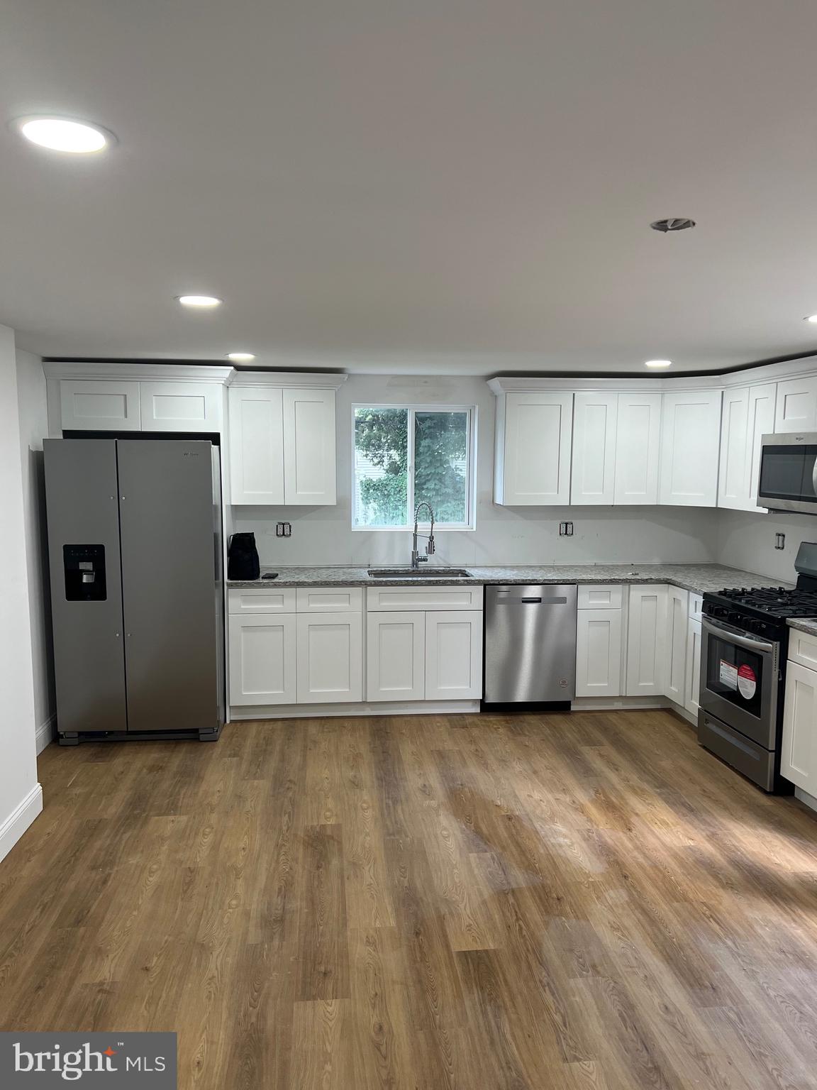 4667 Hawthorne Street Philadelphia, PA 19124 - Photo 6 of 21 a large kitchen with stainless steel appliances granite countertop a stove a sink and a refrigerator
