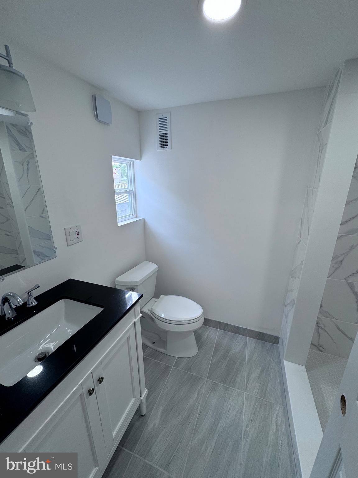 4667 Hawthorne Street Philadelphia, PA 19124 - Photo 9 of 21 a bathroom with a granite countertop toilet and sink