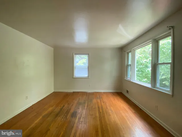 a view of a room with wooden floor and windows