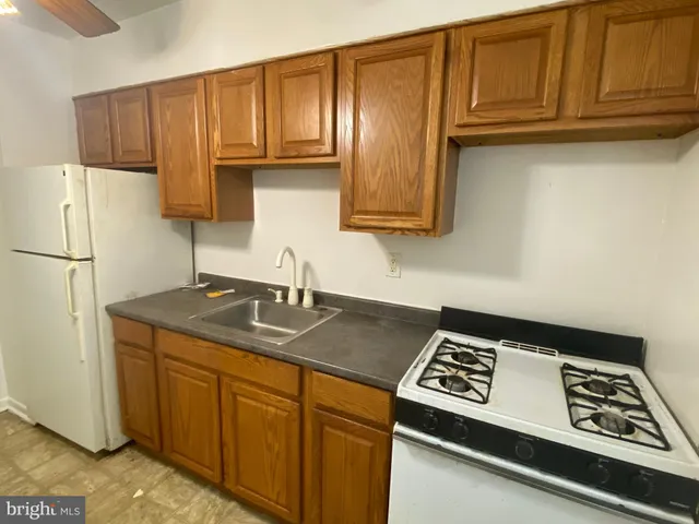 a kitchen with granite countertop a sink stove and refrigerator