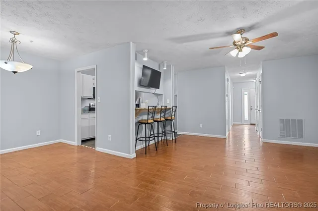 a view of empty room with wooden floor