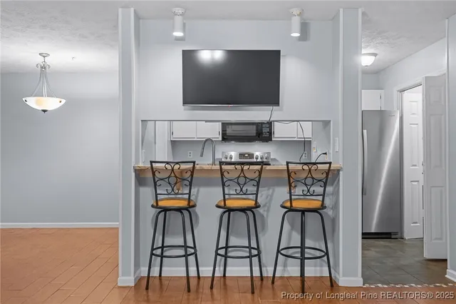a view of kitchen with microwave and wooden floor
