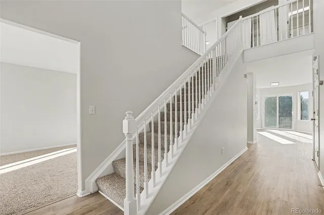 a view of staircase with railing and white walls