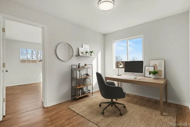 a view of a workspace with furniture and a window
