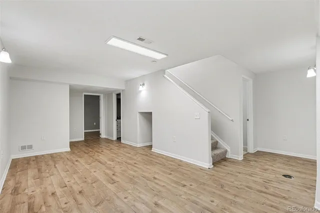 a view of a livingroom with wooden floor and stairs