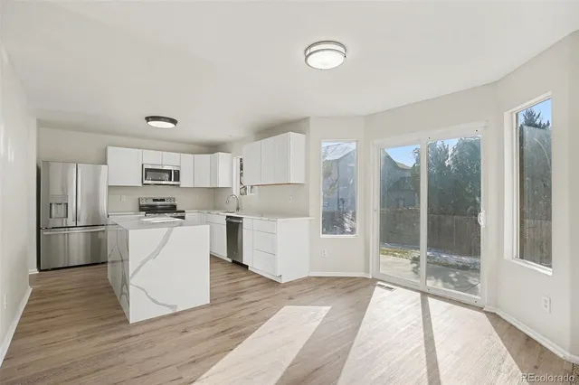a kitchen with white cabinets and stainless steel appliances