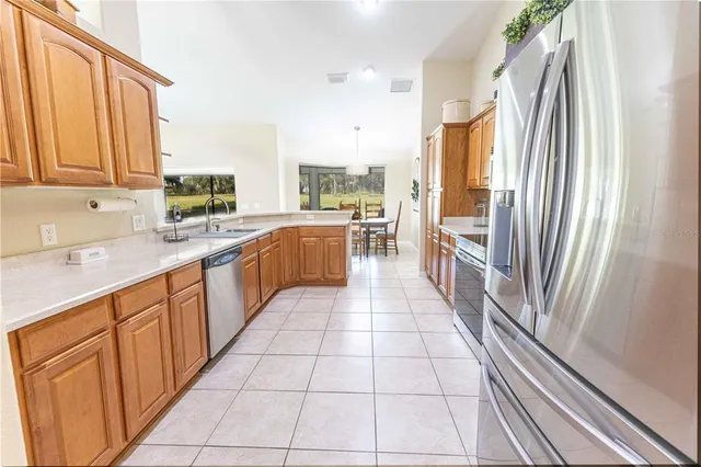 a kitchen with stainless steel appliances granite countertop a refrigerator and a stove top oven