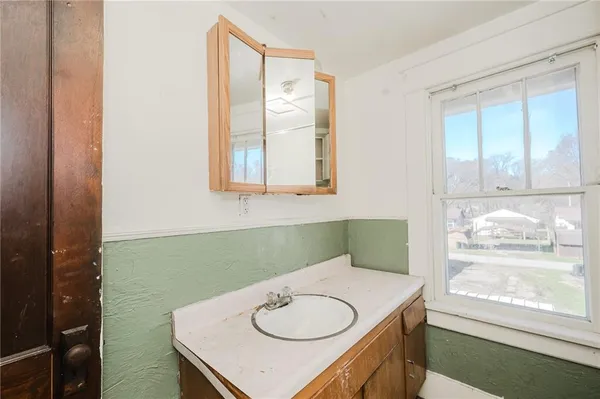 a bathroom with a sink a toilet and a window