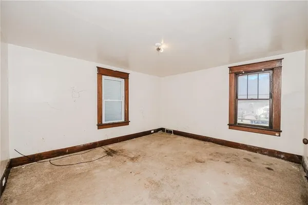 an empty room with windows and closet