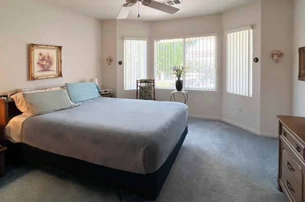 a bed sitting in a spacious bedroom next to a window