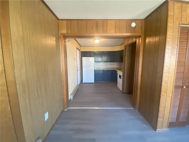 a view of entryway with kitchen and wooden floor