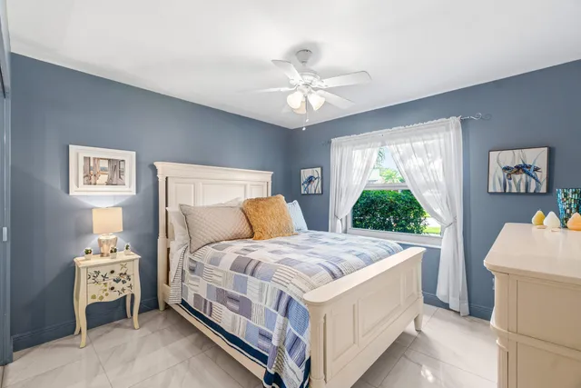 a bedroom with a bed a window and a chandelier