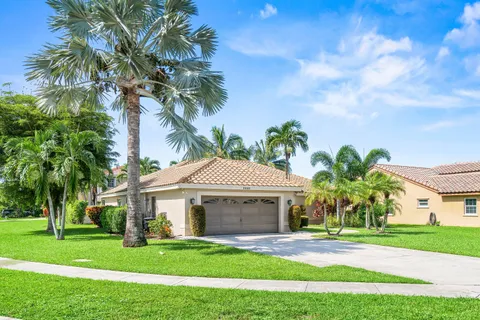 a front view of a house with a garden and trees