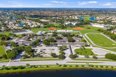 a front view of a house with a yard and potted plants