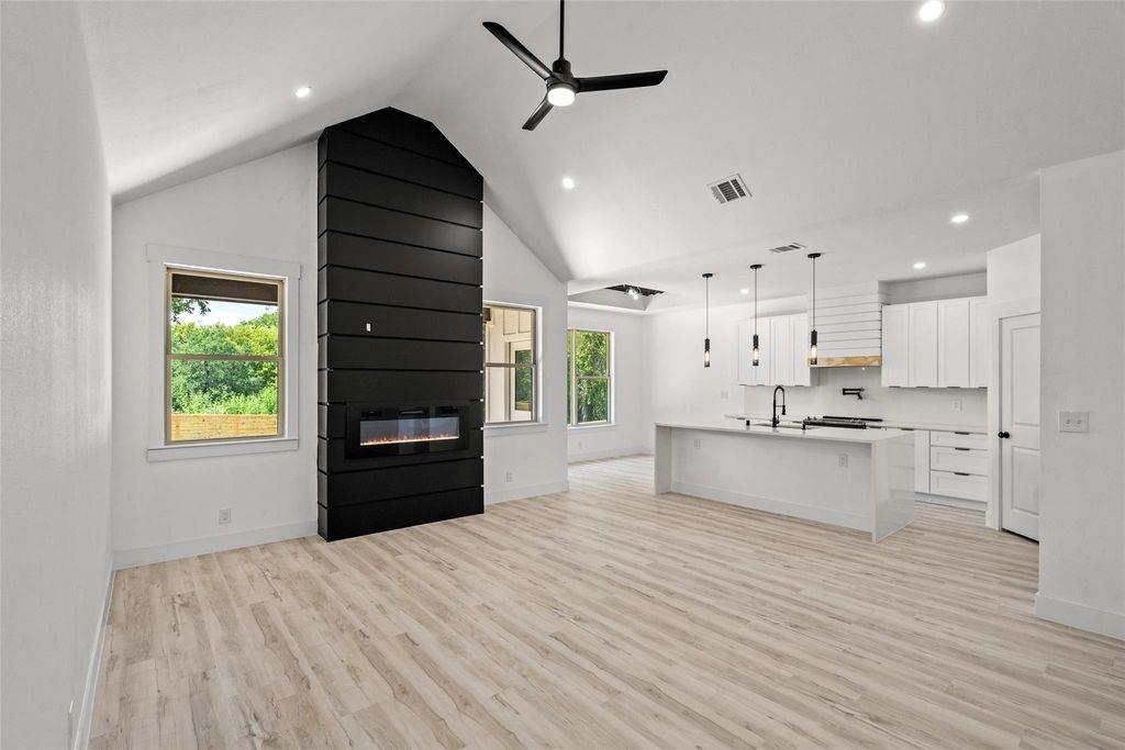 1017 Cedarcrest Drive Mesquite, TX 75149 - Photo 20 of 20 a large white kitchen with kitchen island a refrigerator a stove a sink dishwasher and a oven with wooden floor