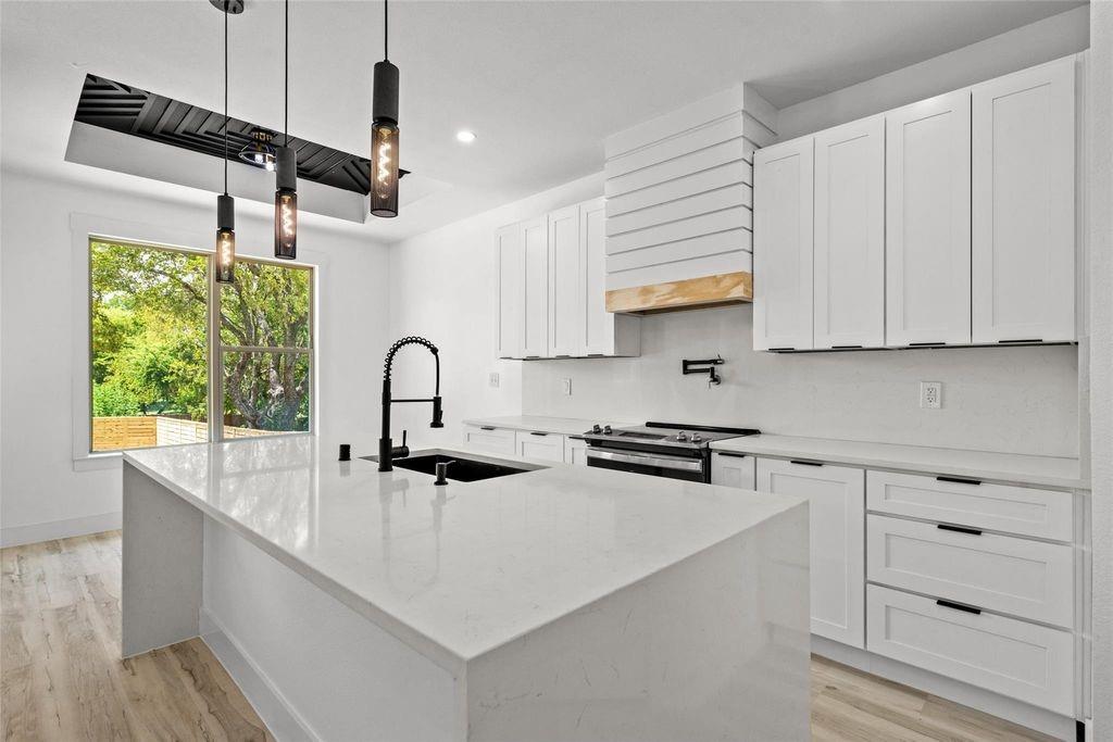 1017 Cedarcrest Drive Mesquite, TX 75149 - Photo 3 of 20 a kitchen with stainless steel appliances granite countertop a sink a stove and a wooden floors