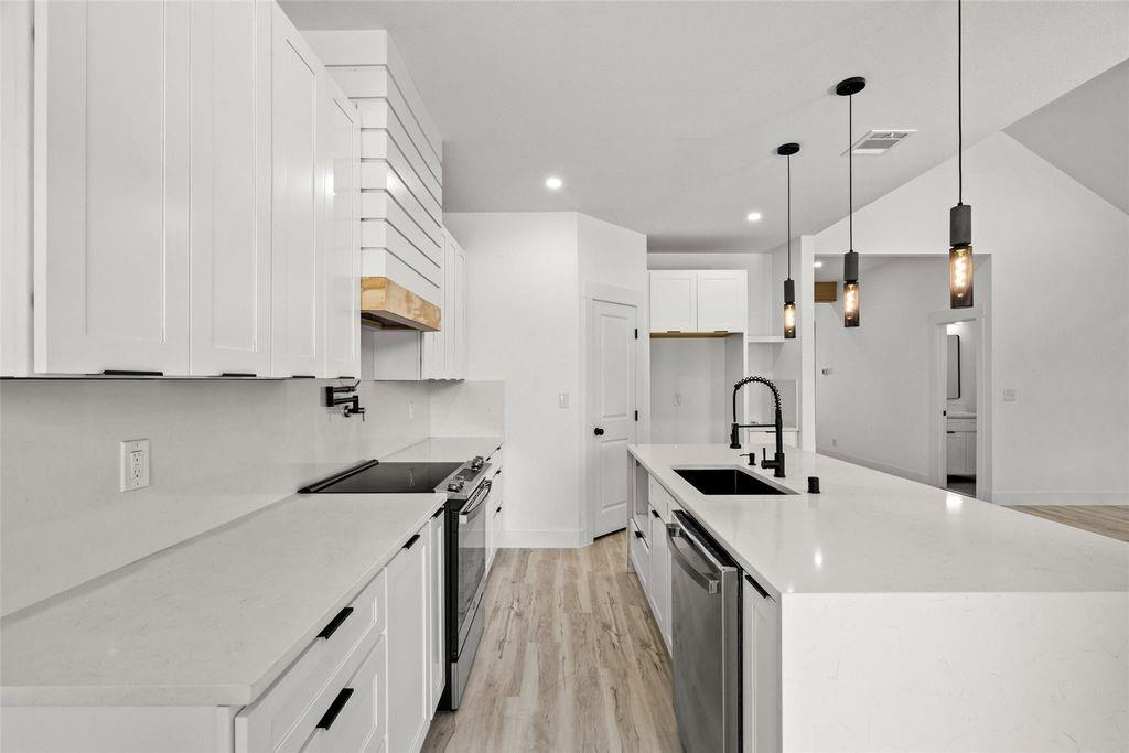 1017 Cedarcrest Drive Mesquite, TX 75149 - Photo 4 of 20 a kitchen with stainless steel appliances a sink stove and cabinets