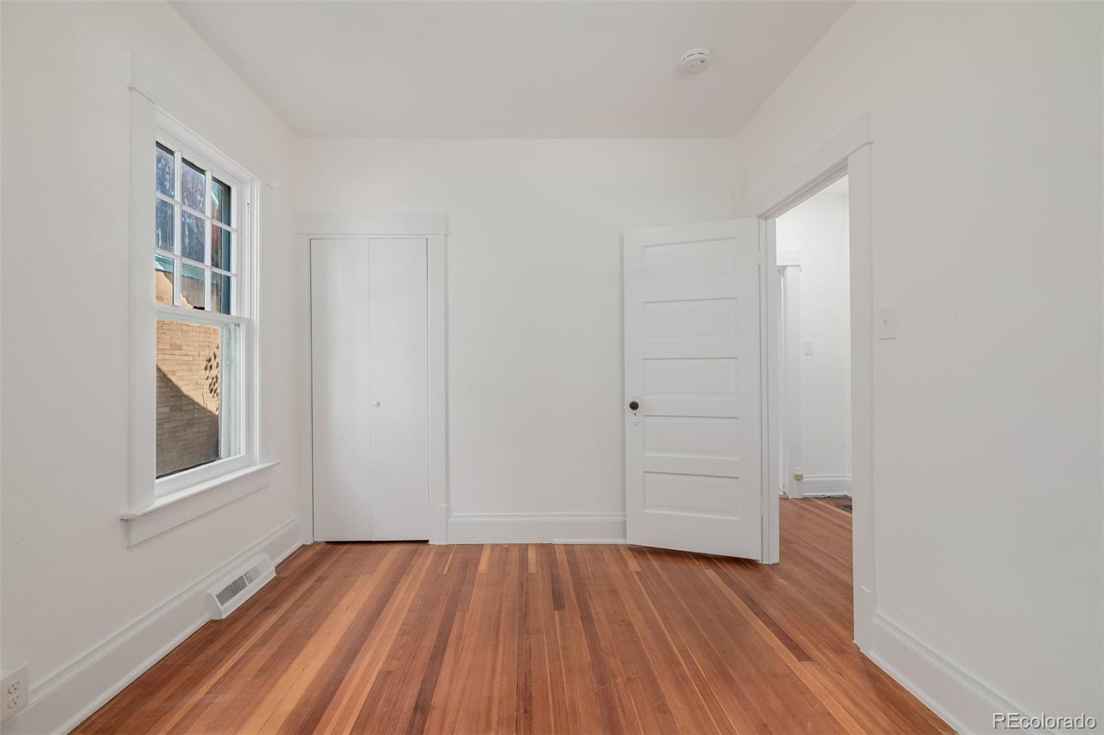 3534 Clay Street Denver, CO 80211 - Photo 25 of 50 an empty room with wooden floor closet and windows