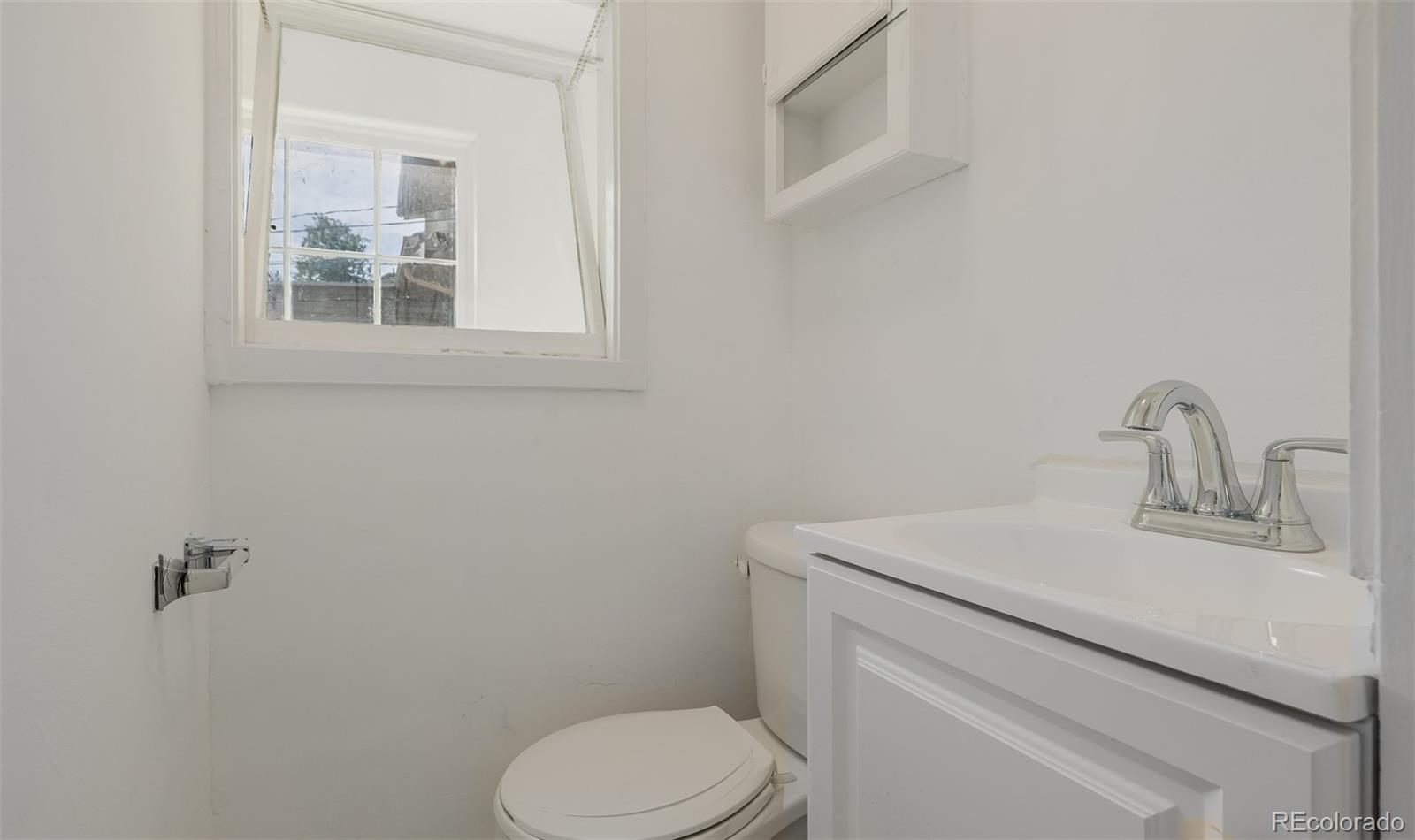 3534 Clay Street Denver, CO 80211 - Photo 26 of 50 a bathroom with a toilet sink and mirror