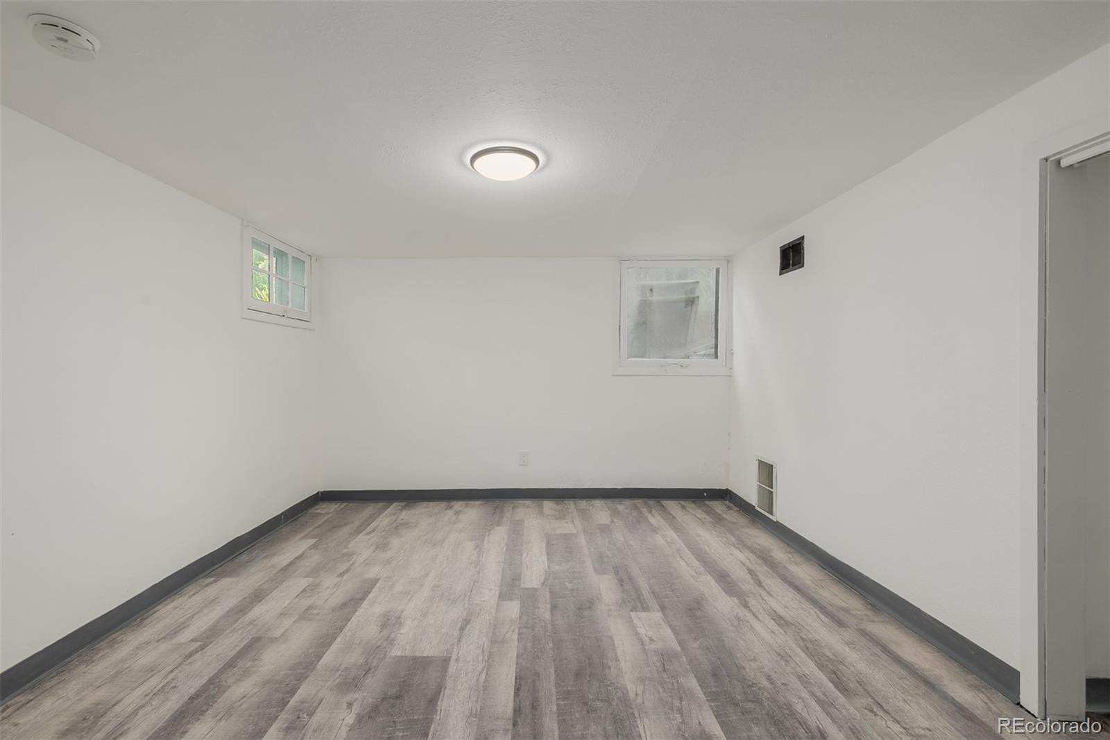3534 Clay Street Denver, CO 80211 - Photo 28 of 50 an empty room with wooden floor and windows