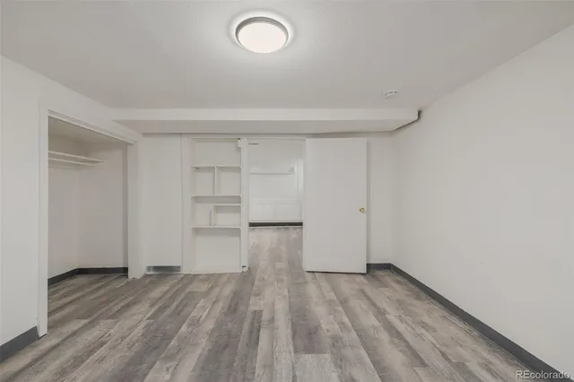a view of empty room with wooden floor