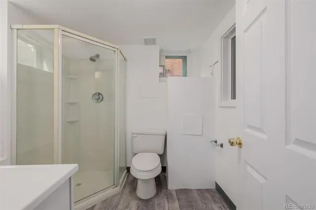 a bathroom with a toilet and a shower