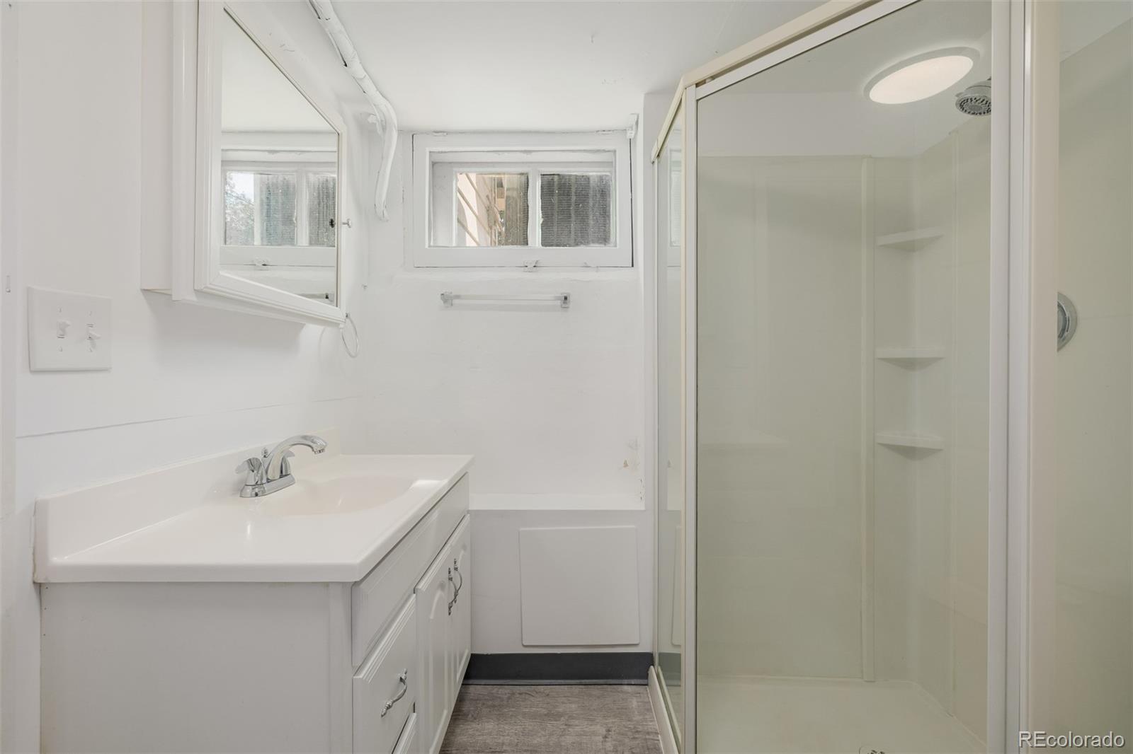 3534 Clay Street Denver, CO 80211 - Photo 32 of 50 a bathroom with a sink a mirror and shower