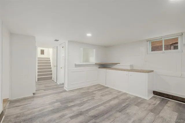 a view of empty room with wooden floor and window