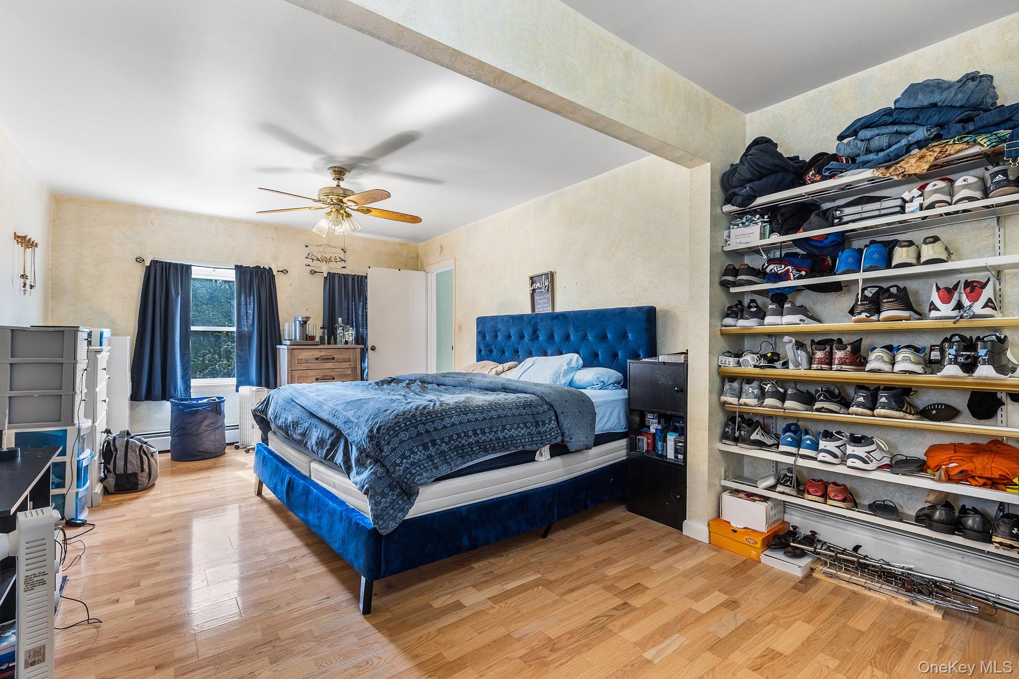43 Taylor Road Parksville, NY 12768 - Photo 22 of 29 Bedroom featuring wood-finish flooring, a ceiling fan with light fixture, and windows with dark window treatments