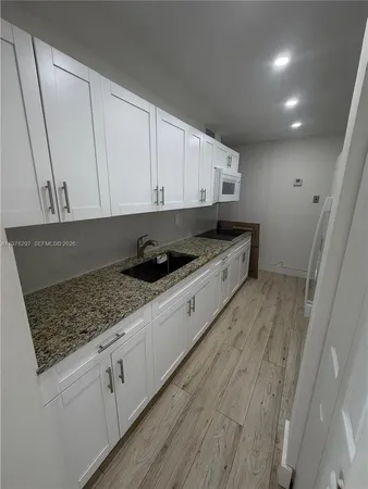 a kitchen with stainless steel appliances granite countertop a sink stove and cabinets