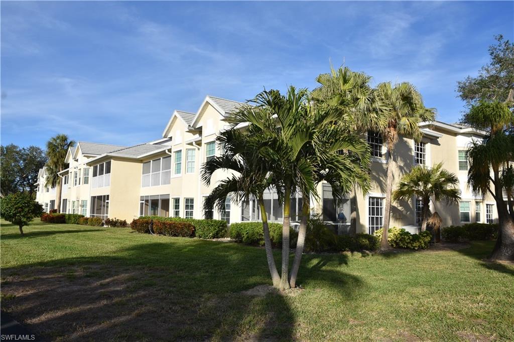 2839 Aintree Lane, Unit B202 Naples, FL 34112 - Photo 24 of 31 a view of a white house with a big yard and potted plants and large trees