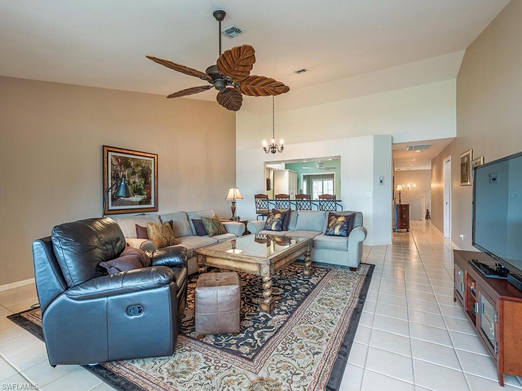 2839 Aintree Lane, Unit B202 Naples, FL 34112 - Photo 8 of 31 a living room with furniture a flat screen tv and a ceiling fan