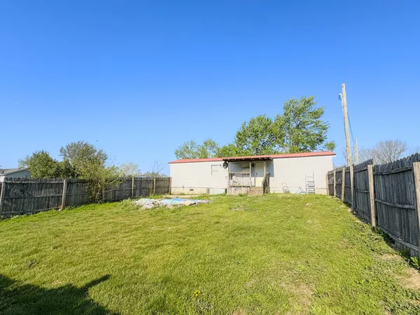 a backyard of a house with plants and wooden fence