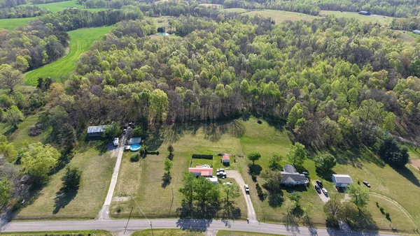 an aerial view of residential houses with outdoor space and trees