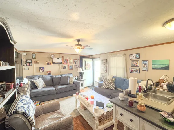 a living room with furniture a flat screen tv and a large window